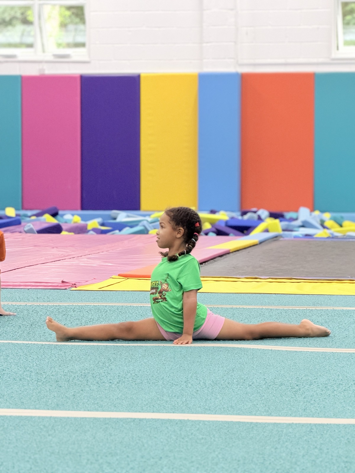 A young gymnast practising the splits on the floor